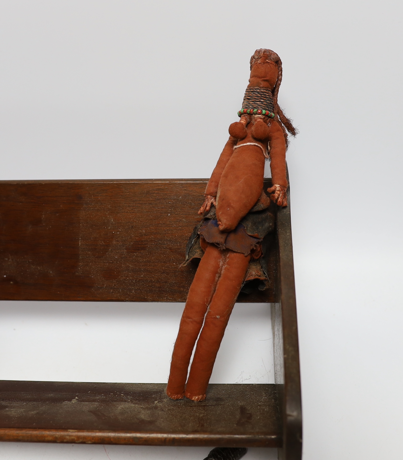 A collection of tribal items including a fabric doll, an African carved wood figure and a dagger and bow, bow 166cm long